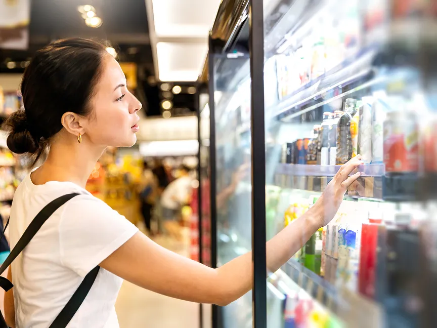 A woman browsing the beverage selection at a grocery store