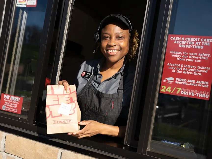 fast food worker handing food through a window