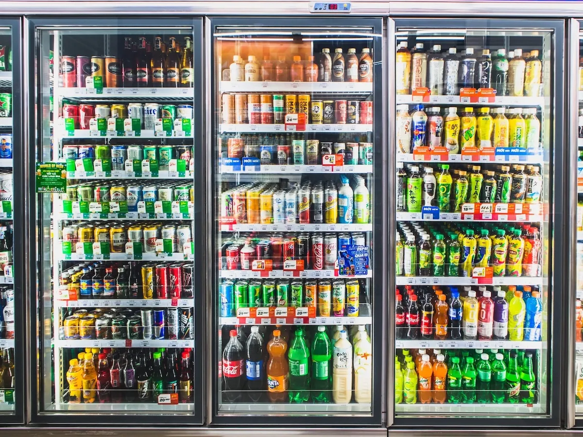 A grocery store refrigerator stocked with various beverages