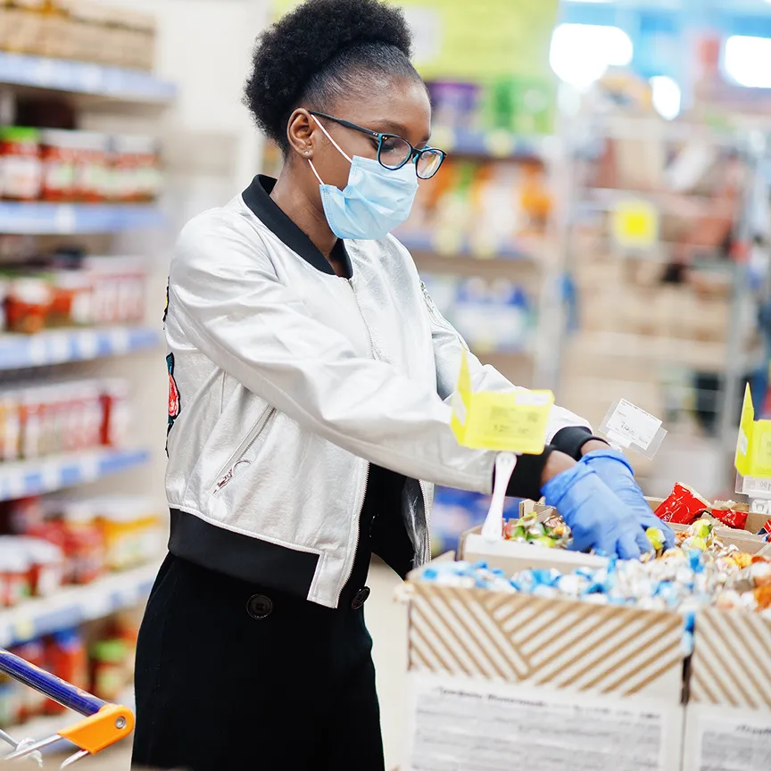 woman in mask stocking store