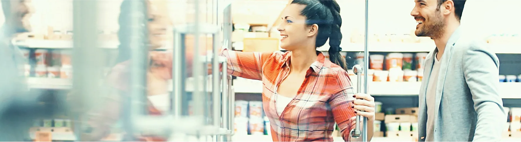 A smiling couple shopping together in a grocery store